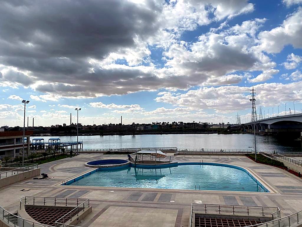 Nile-side hotel terrace pool with bridge in the distance
